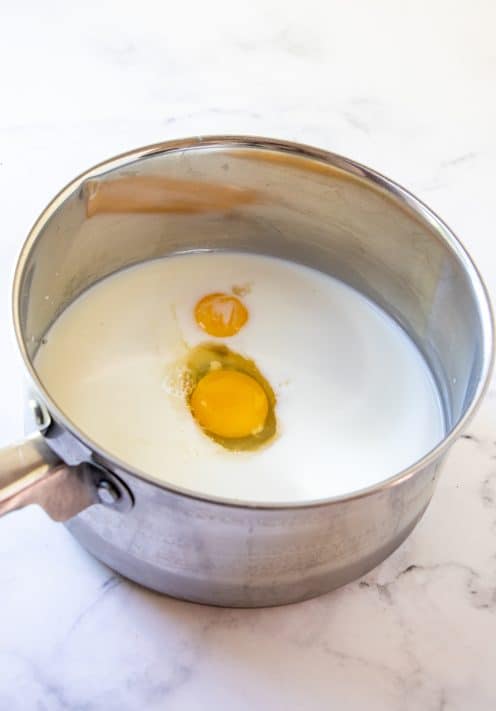 Milk, sugar, cornstarch, salt, egg and egg yolk adding to pan