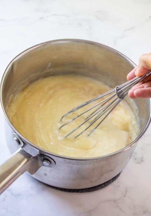 Whisk mixing vanilla and butter into pudding mixture