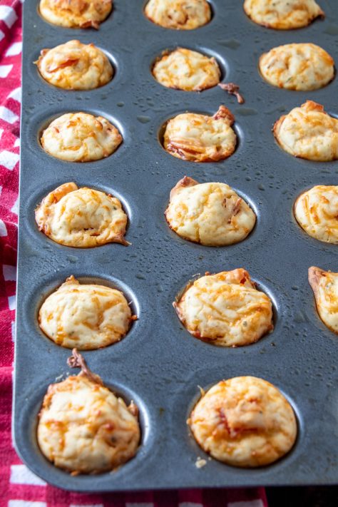 fully baked pizza puffs in a muffin tin.