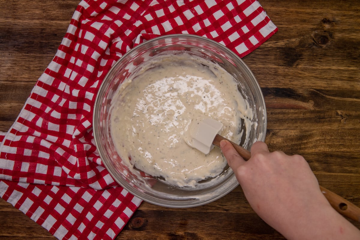 milk added to flour batter in a bowl. 
