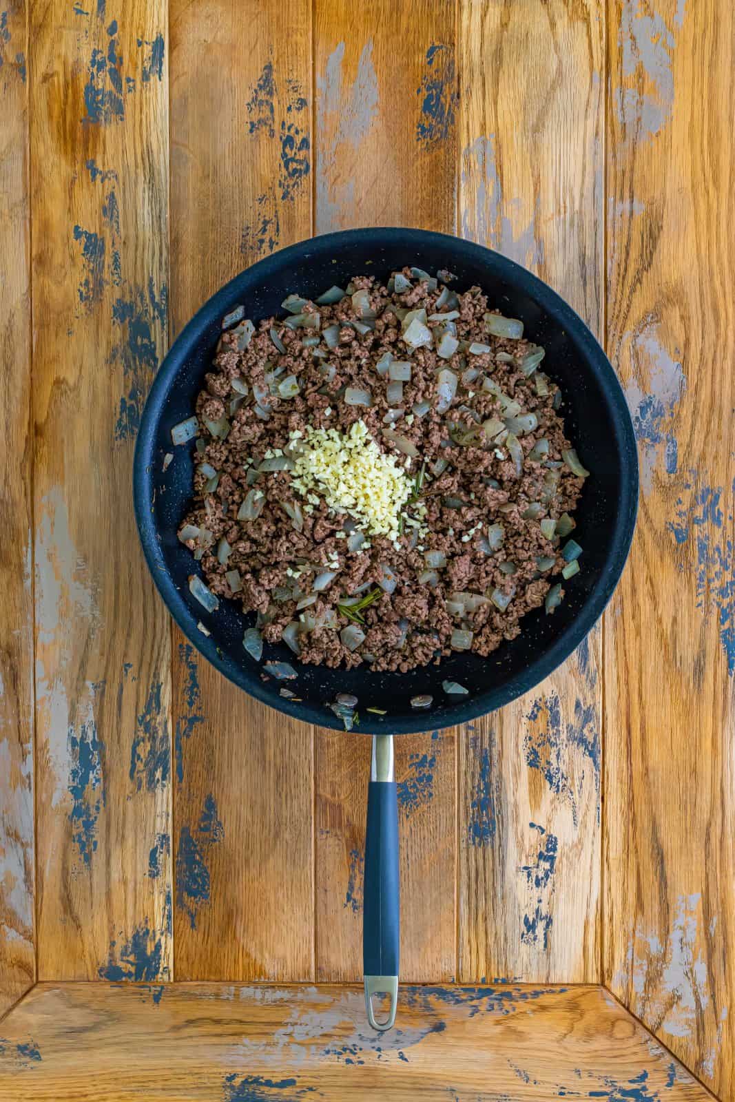 minced garlic added to the cooked ground beef in the skillet. 