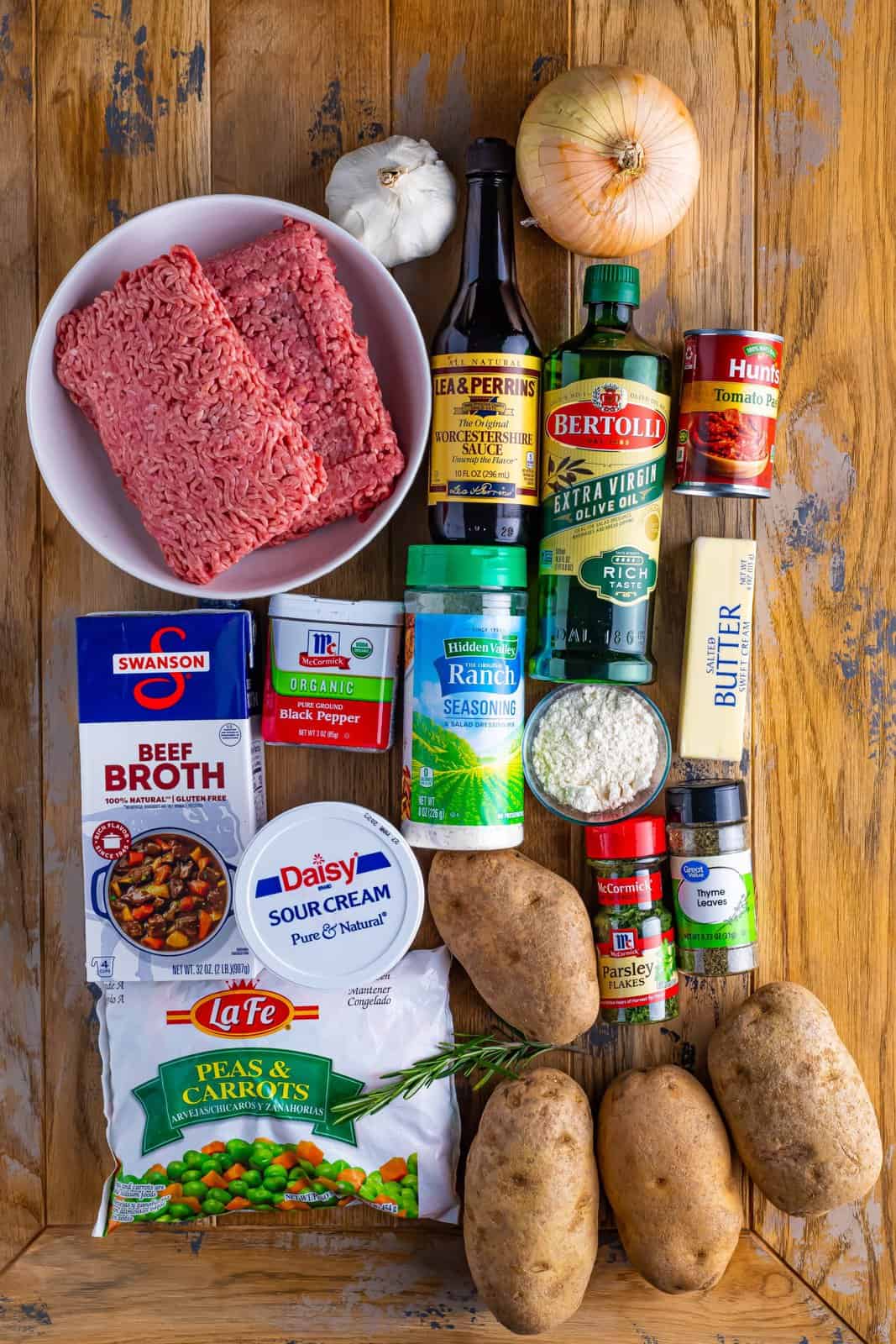 olive oil, onion, parsley, rosemary, thyme, pepper, ground geef or lamb, garlic, worcestershire sauce, flour, tomato paste, frozen peas and carrots, beef broth, potatoes, sour cream, butter, ranch seasoning.