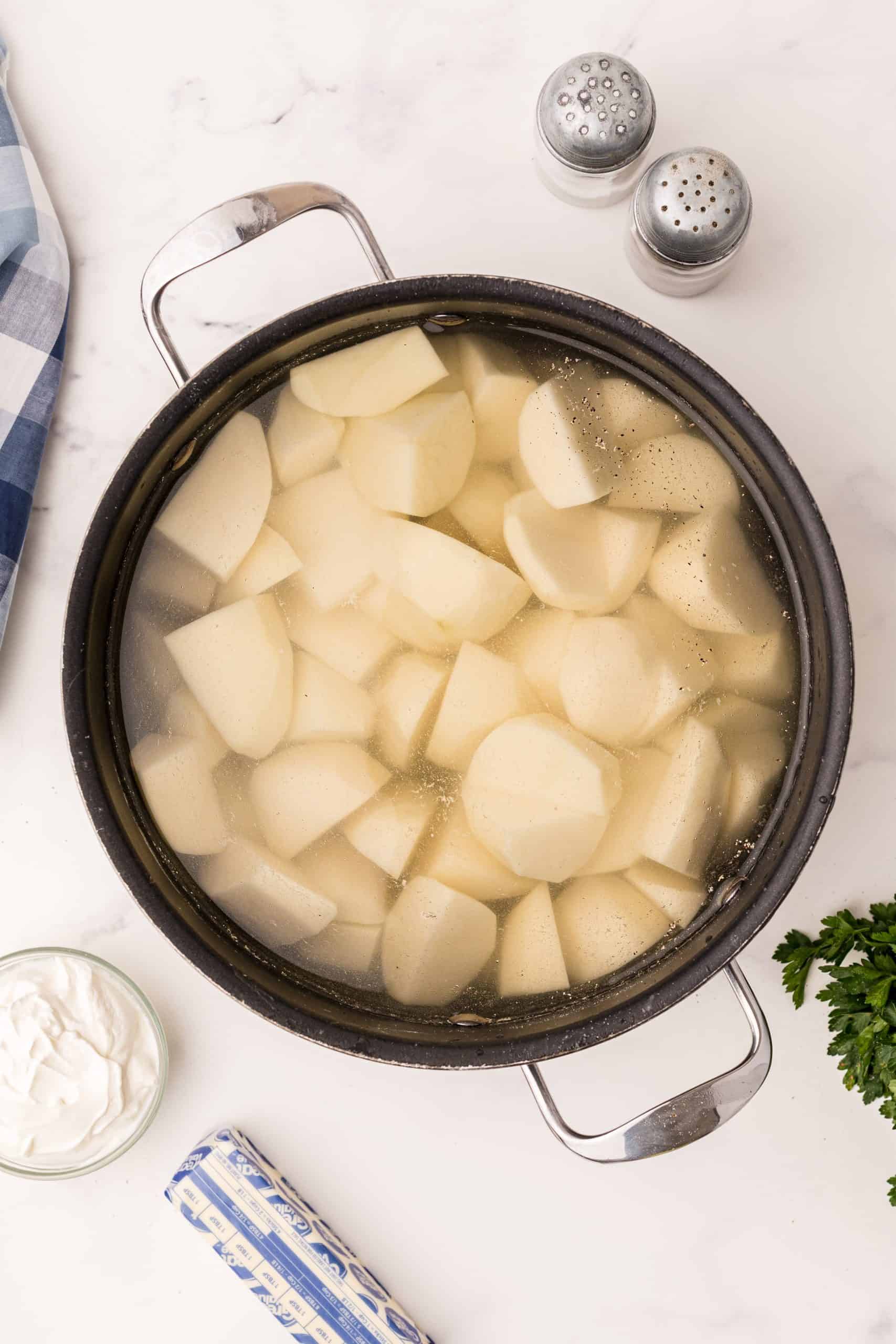 Potatoes boiling in water in a large pot.