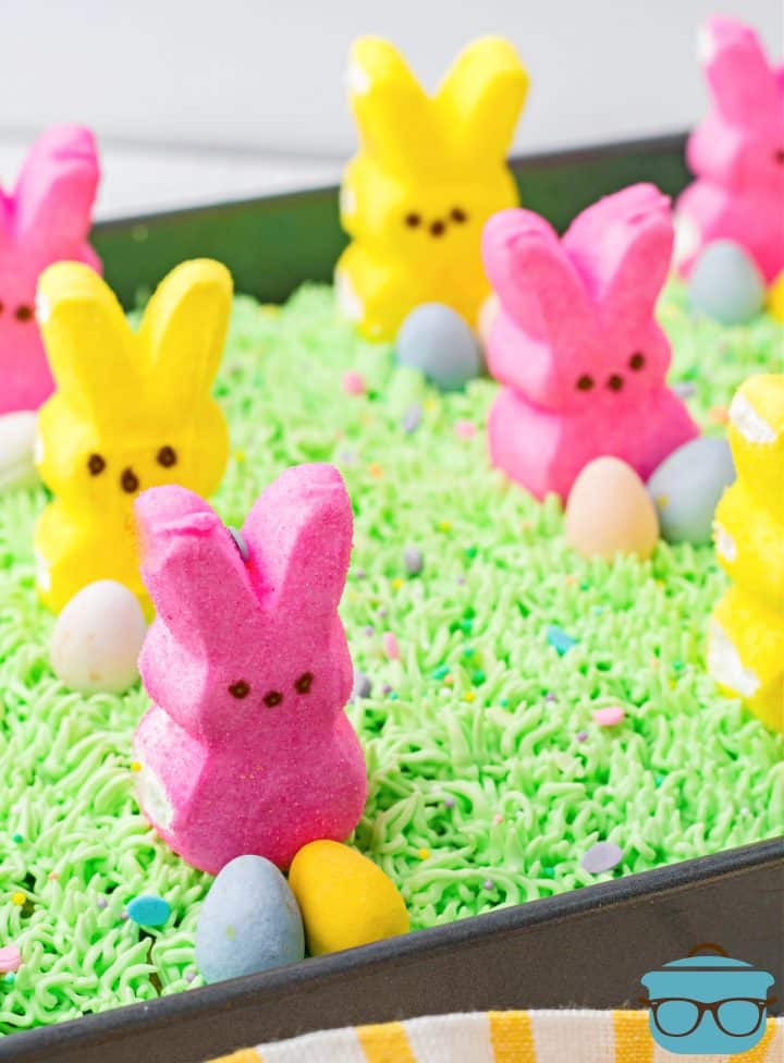 Finished Easter Bunny Poke Cake topped with bunny peeps and mini Cadbury eggs.