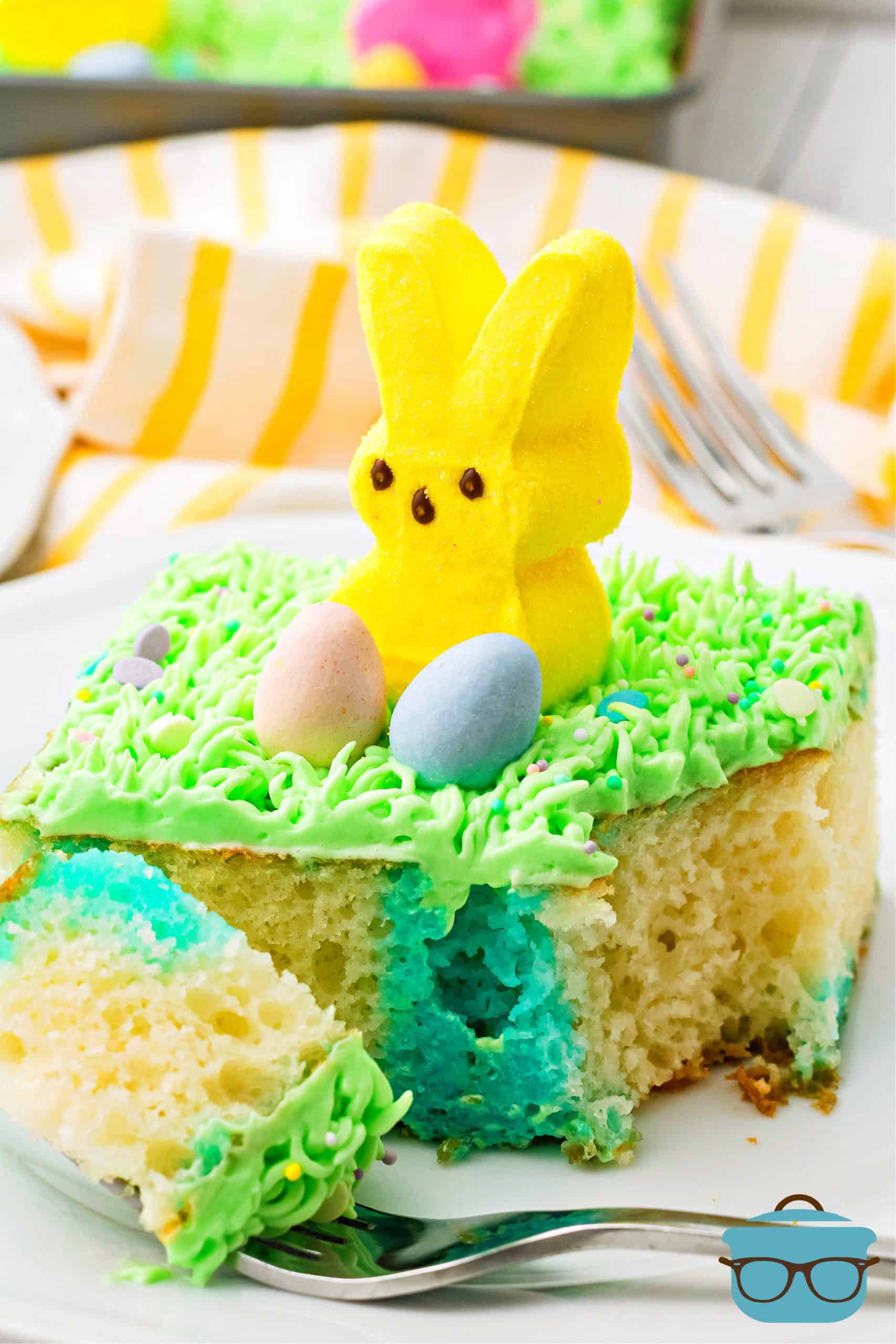 Slice of Easter Bunny Poke Cake Recipe on plate with bite taken out.