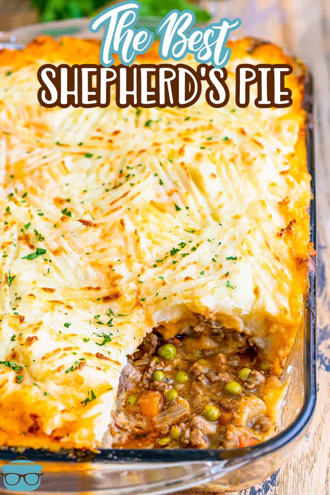 Shepherds Pie shown baked in a clear baking dish with some of the pie removed from the bottom right corner. 