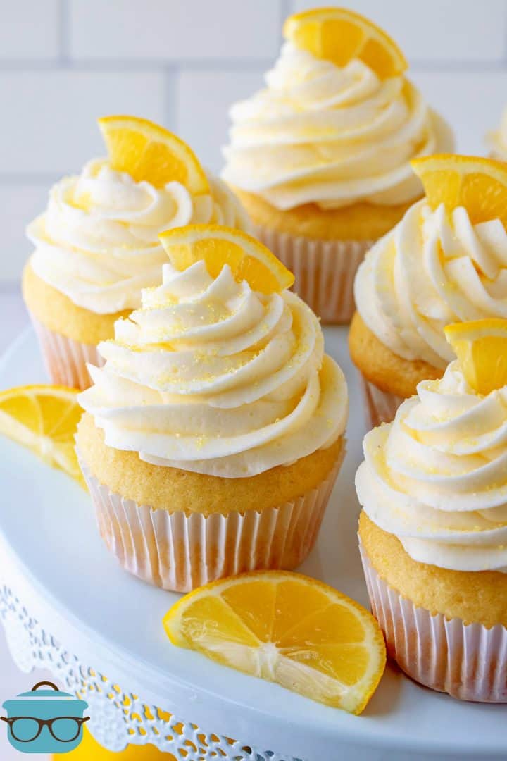 Homemade Lemon Cupcakes on cake stand topped with lemon slices.