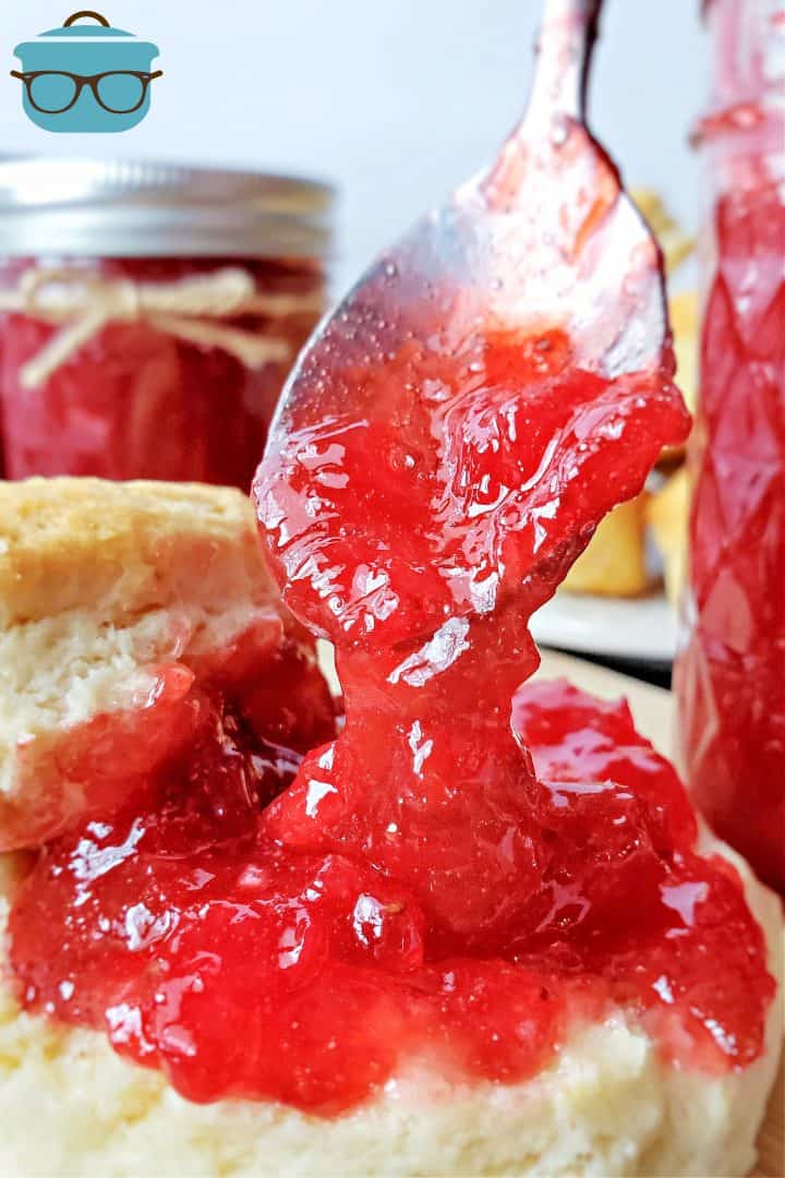 Strawberry Rhubarb Jam being spooned over a biscuit