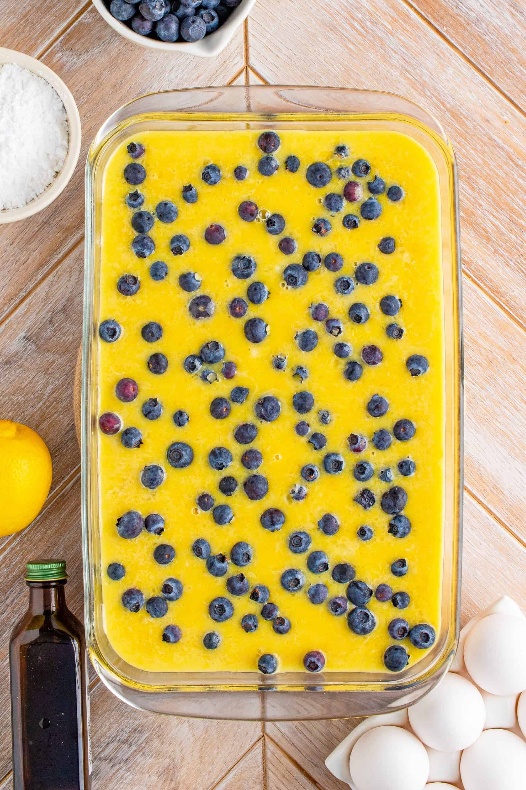 Blueberries sprinkled over filling mixture in baking pan.