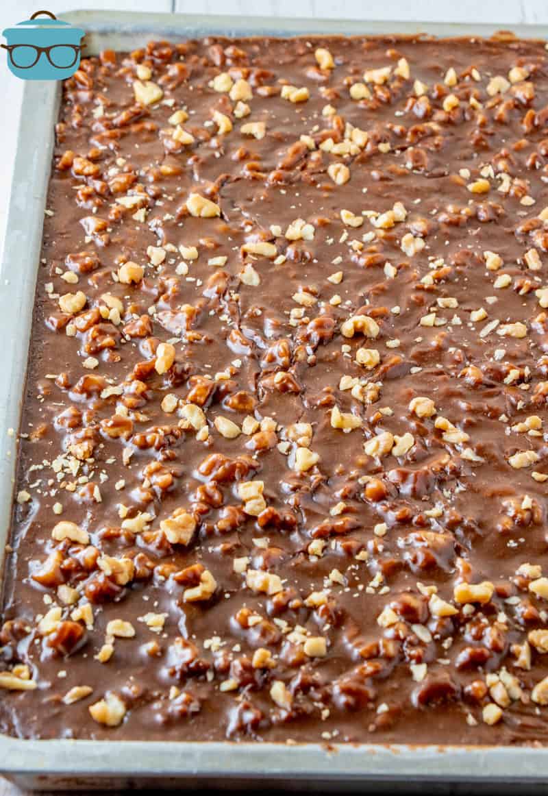 Frosting poured over top of cake and topped with more nuts.