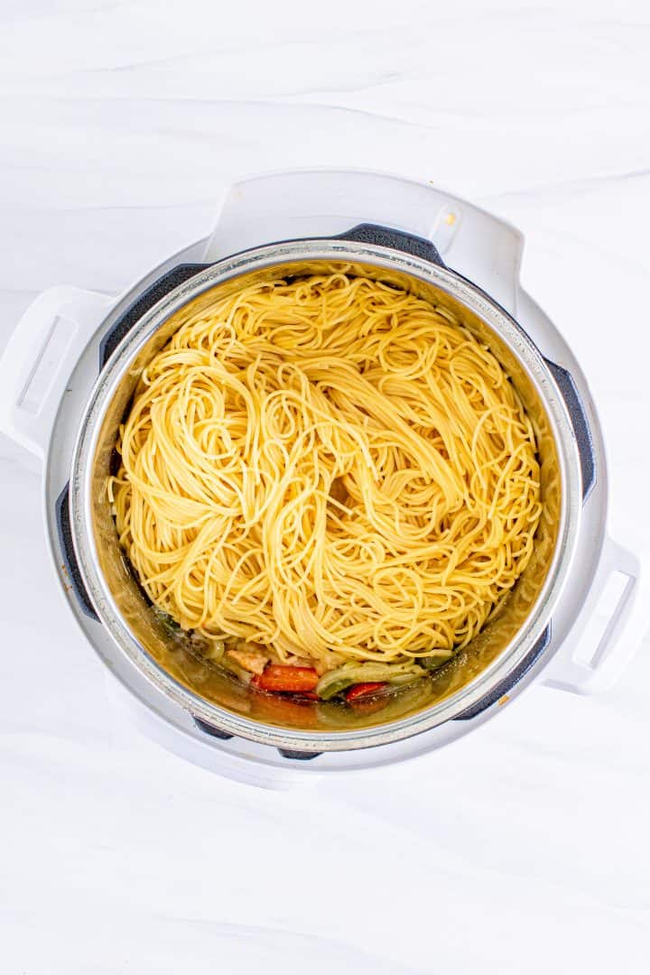 adding cooked spaghetti into the instant pot. 