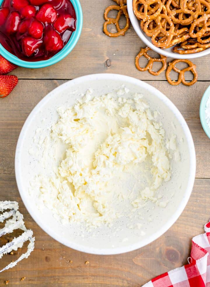 Cream cheese heated in white bowl overhead photo.