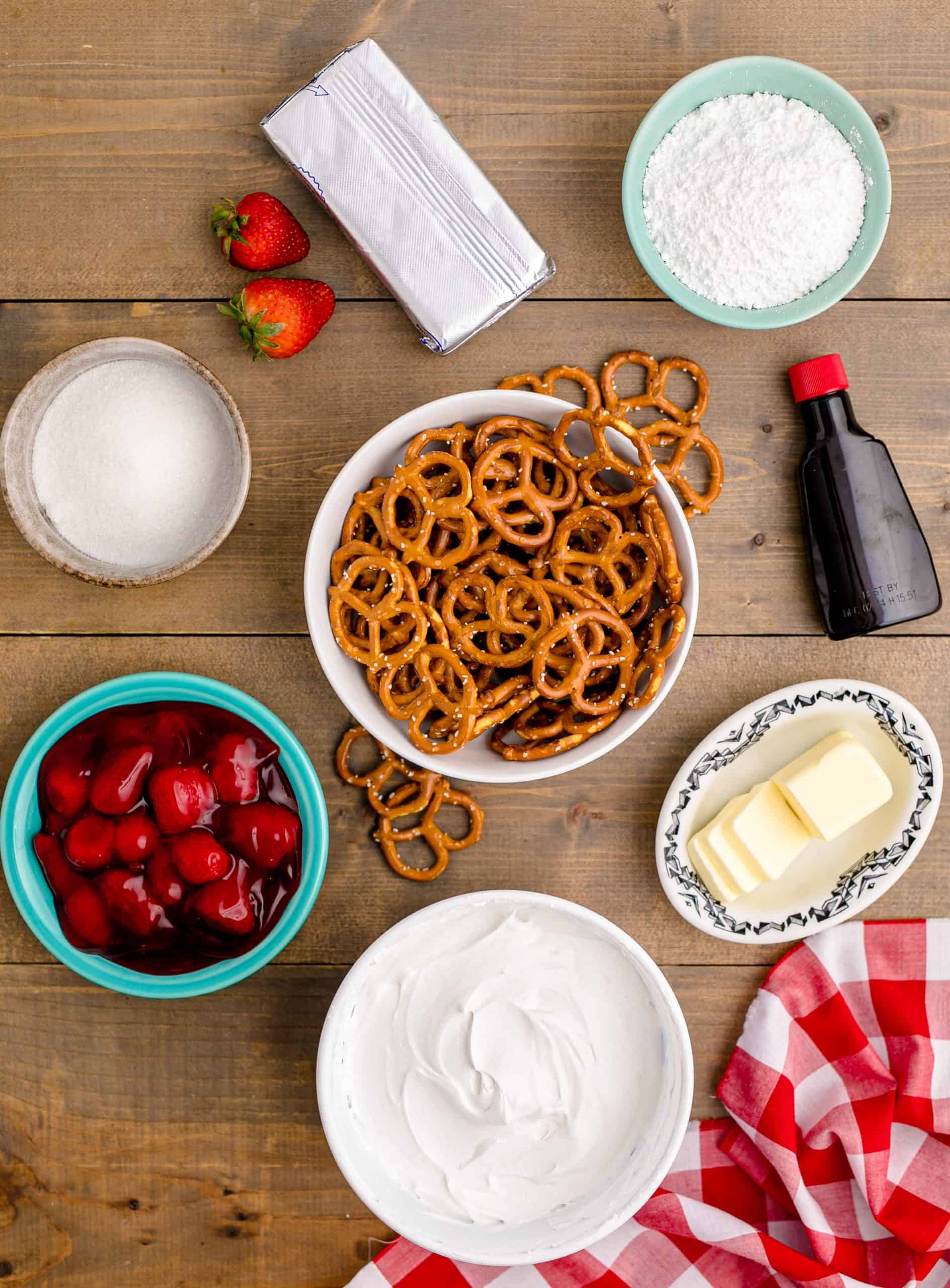 Ingredients needed: pretzels, sugar, salted butter, cream cheese, powdered sugar, almond extract, whipped topping and strawberry pie filling.