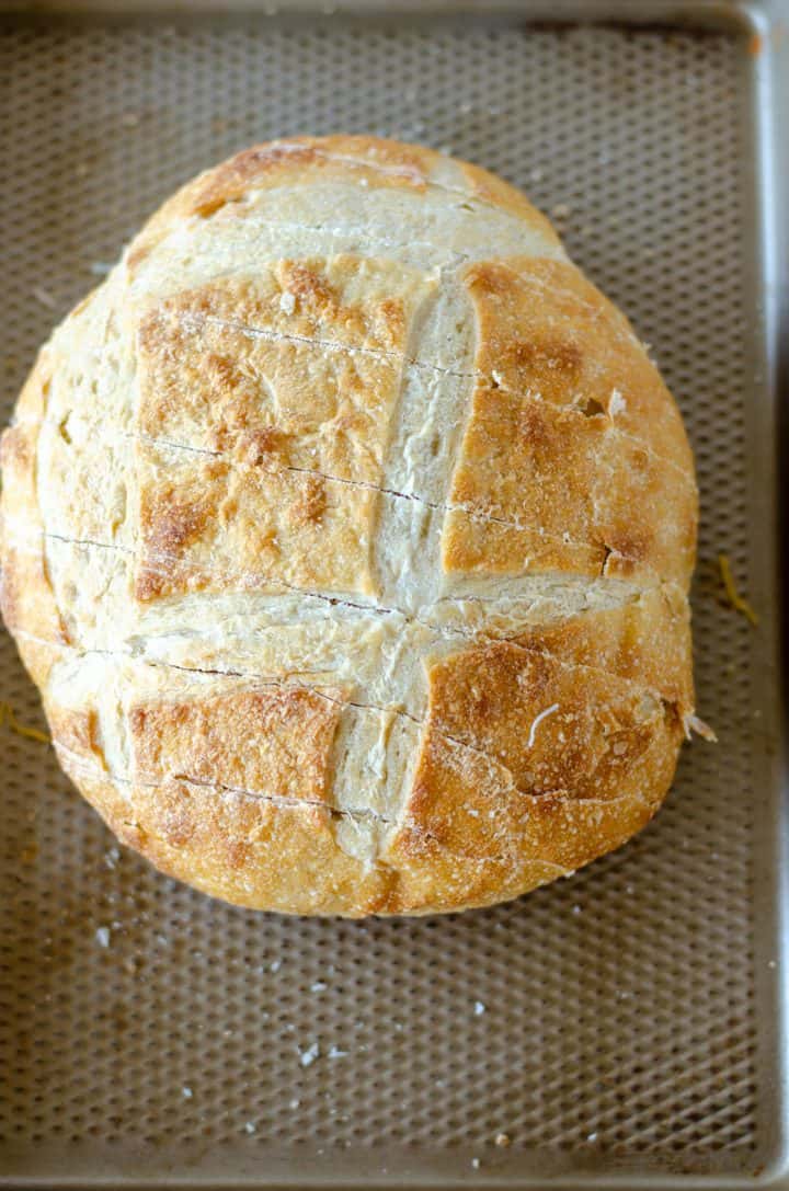Bread on baking pan cut cross length.