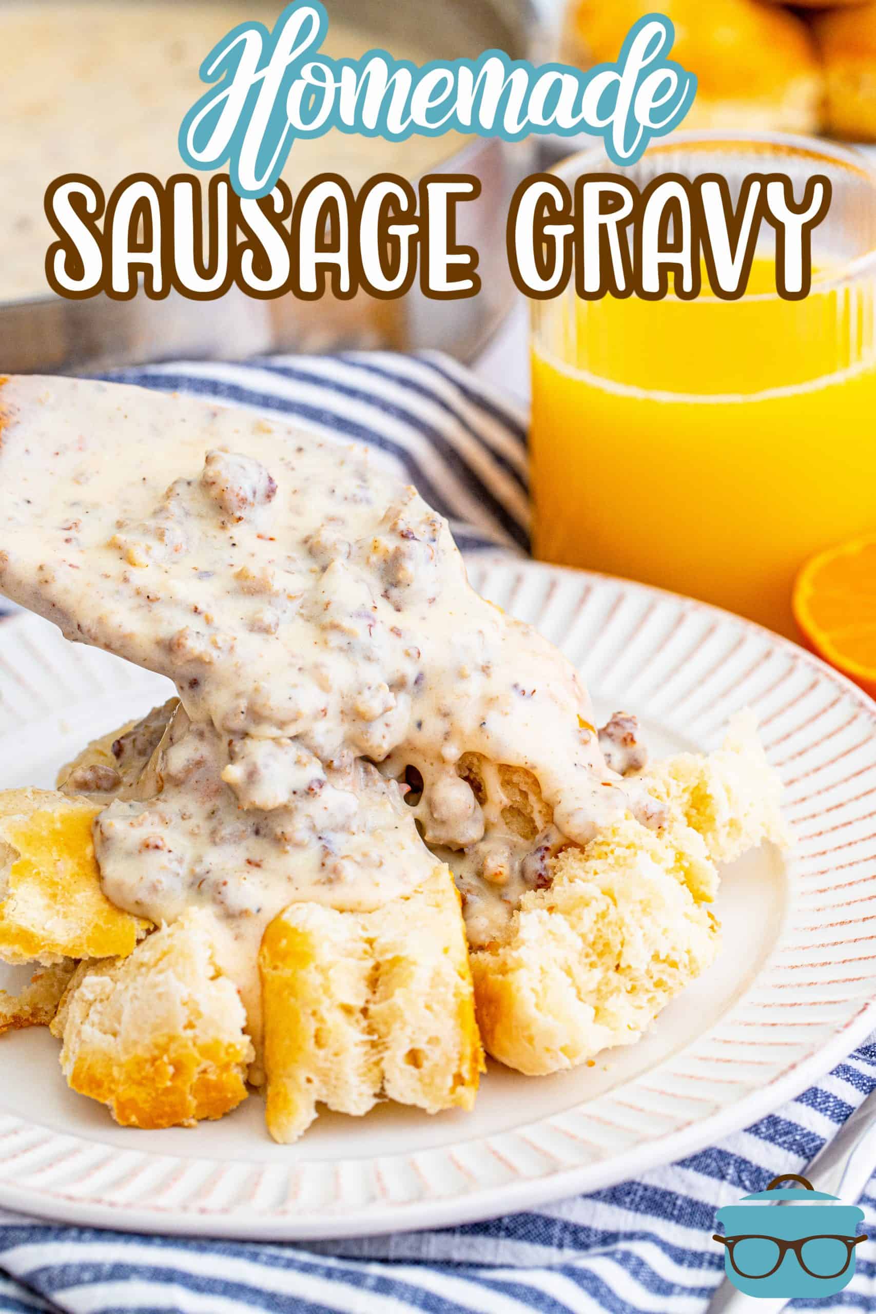 Homemade sausage gravy being spooned over biscuits with wooden spoon on white plate pinterest image.
