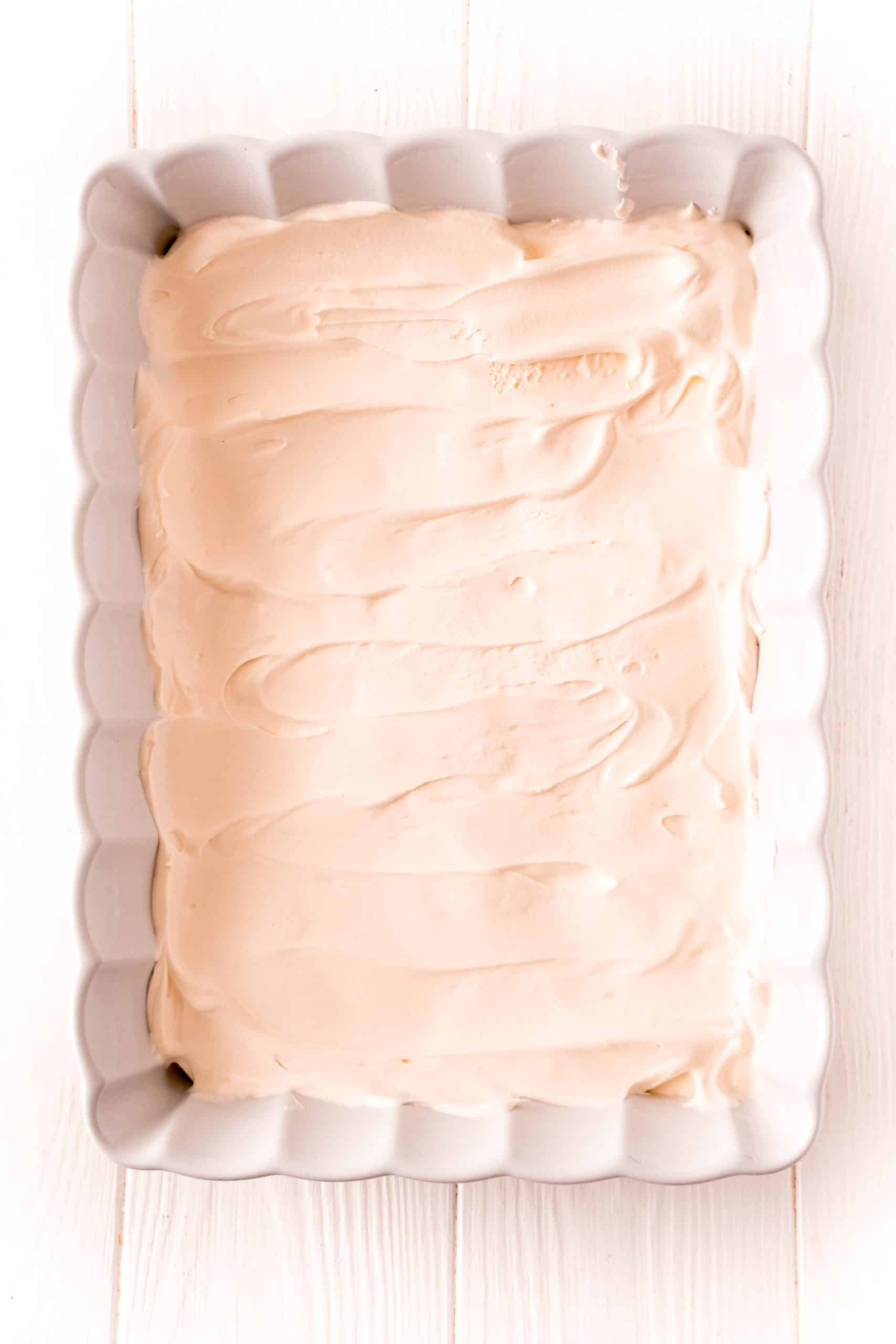 Whipped topping layered evenly over over sweetened condensed milk layer.