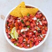 Whole bowl of Pico de Gallo overhead with chips and lime square image