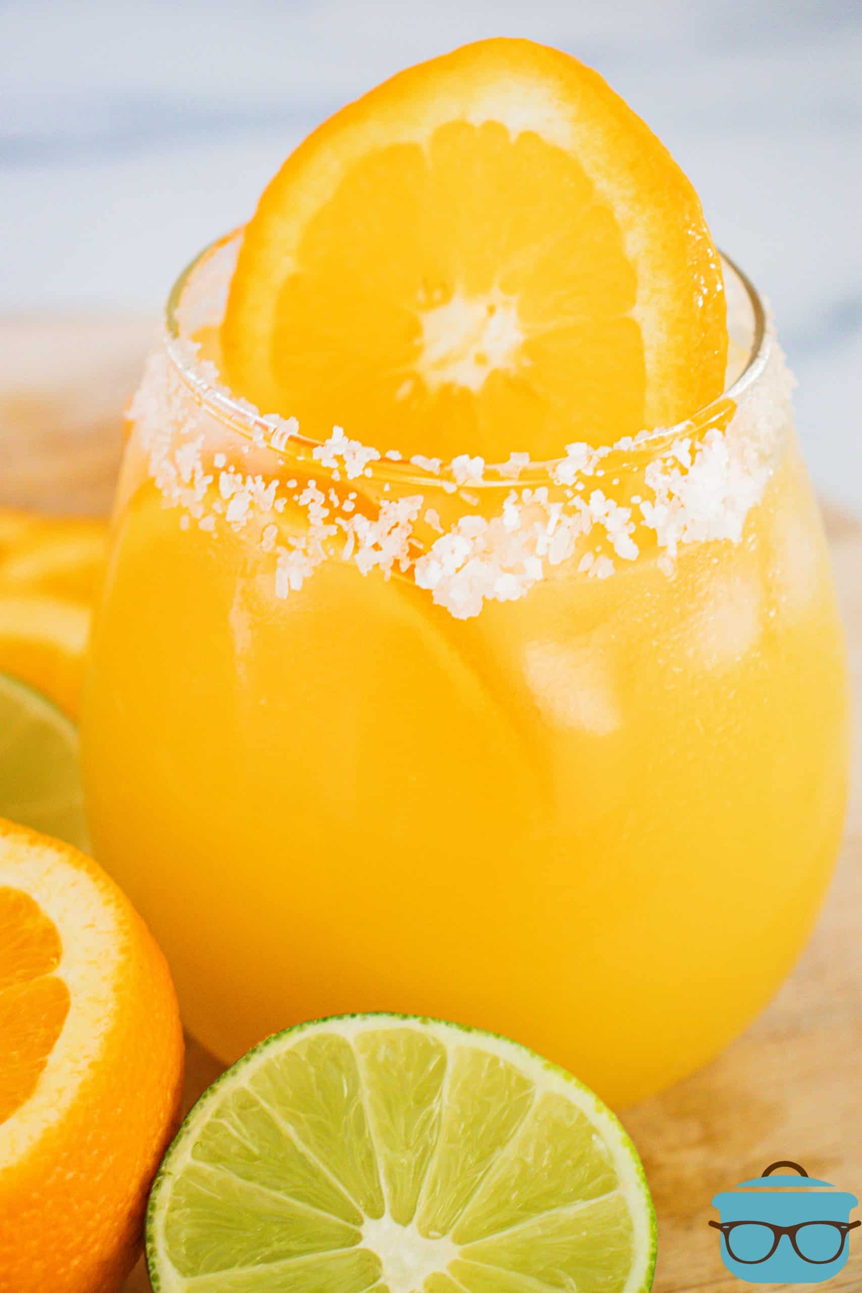 Salt lining the rim of the Orange Margaritas in glass with orange slices.