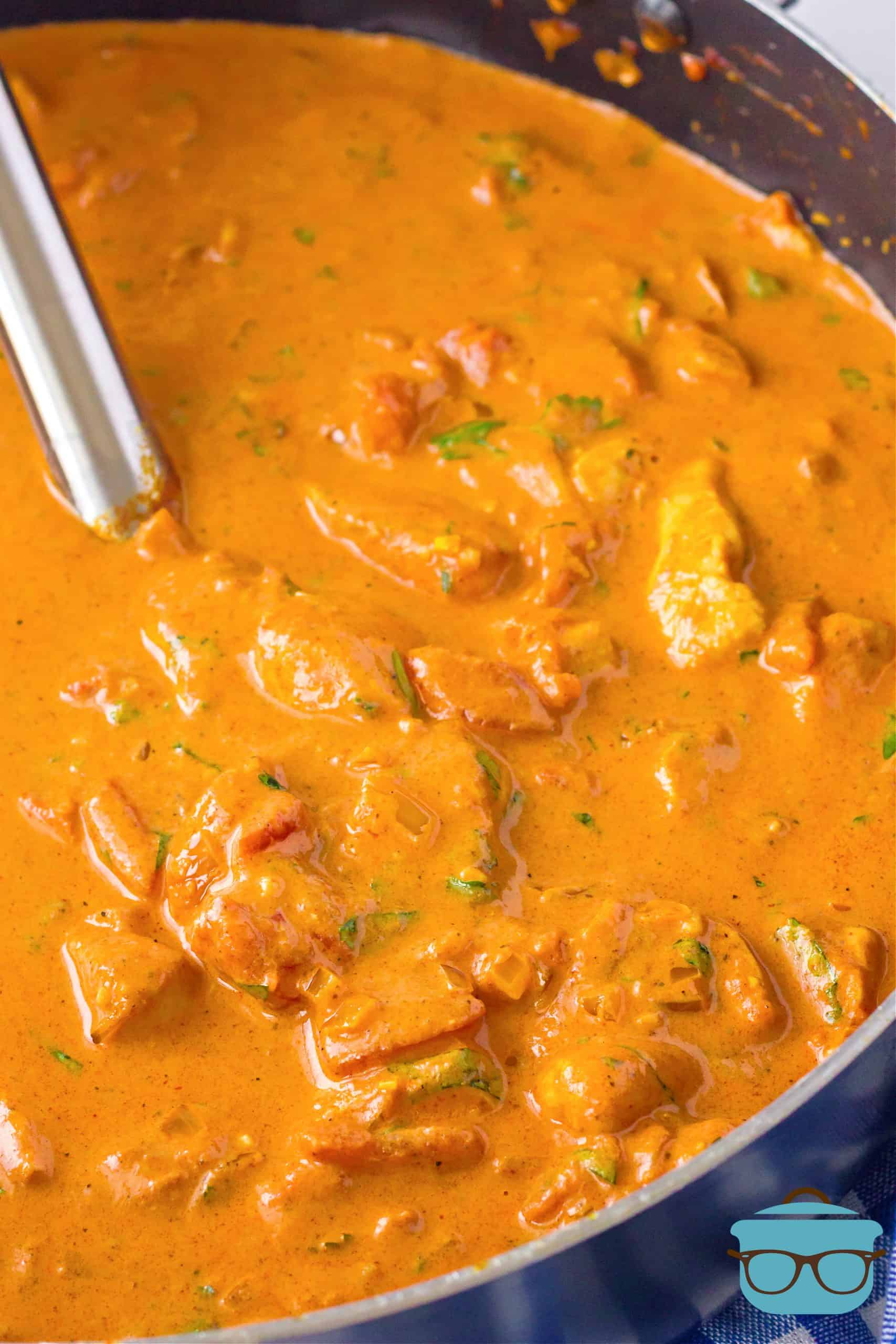 Pan of Creamy Butter Chicken with serving spoon in pan.