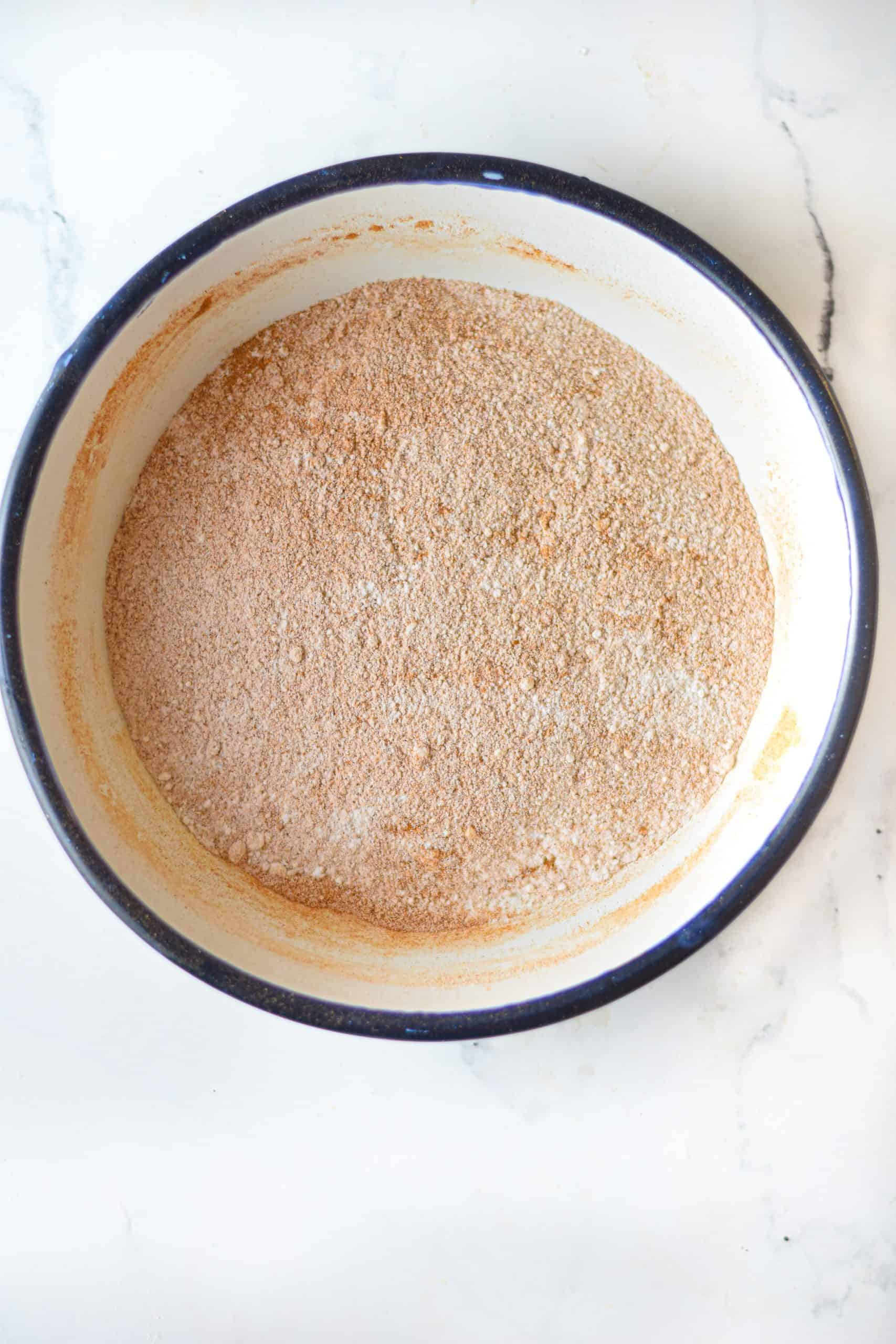 cinnamon and sugar mixed together in a white shallow bowl.