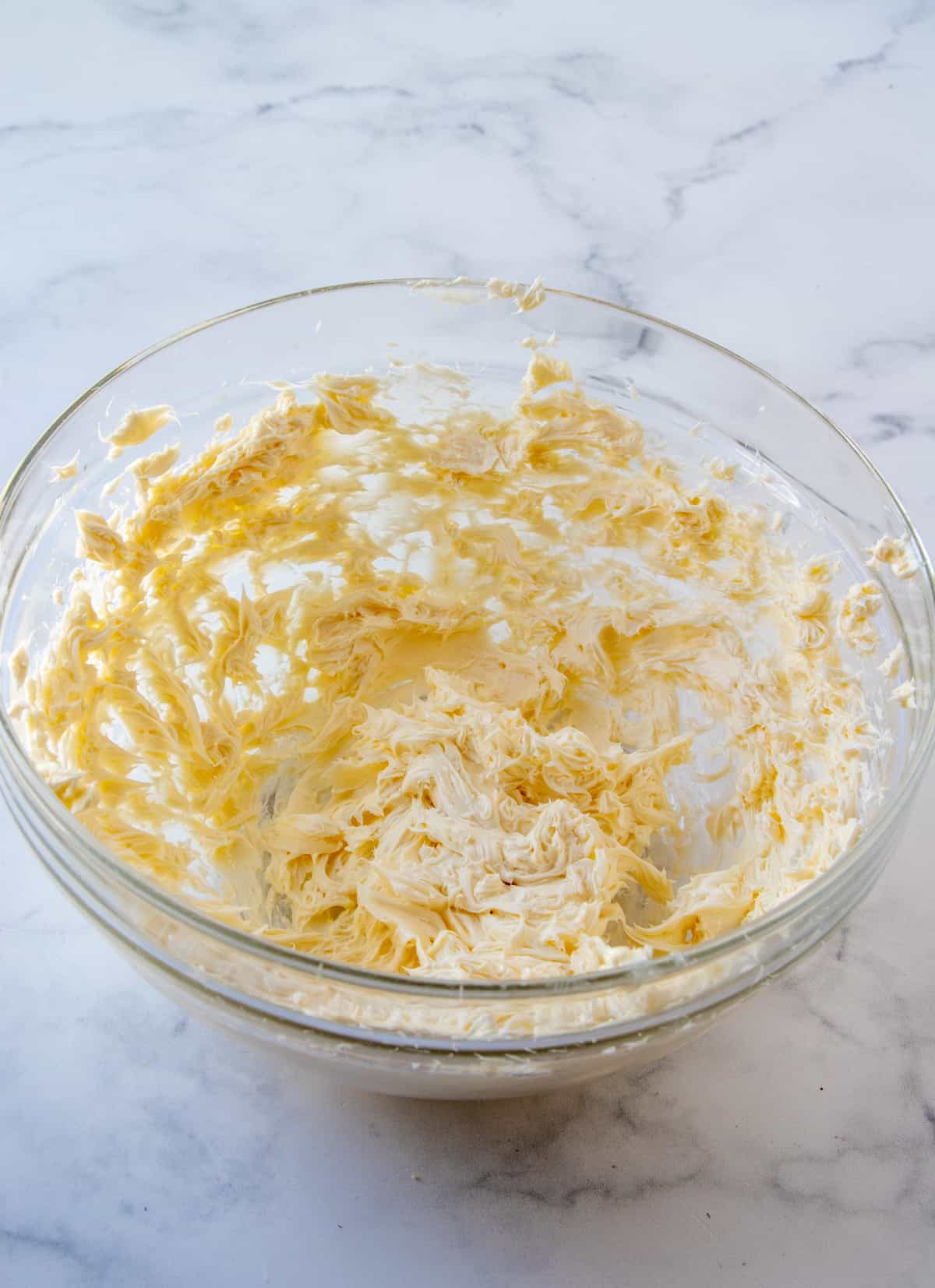 Butter and sugar that have been mixed together in a clear bowl.