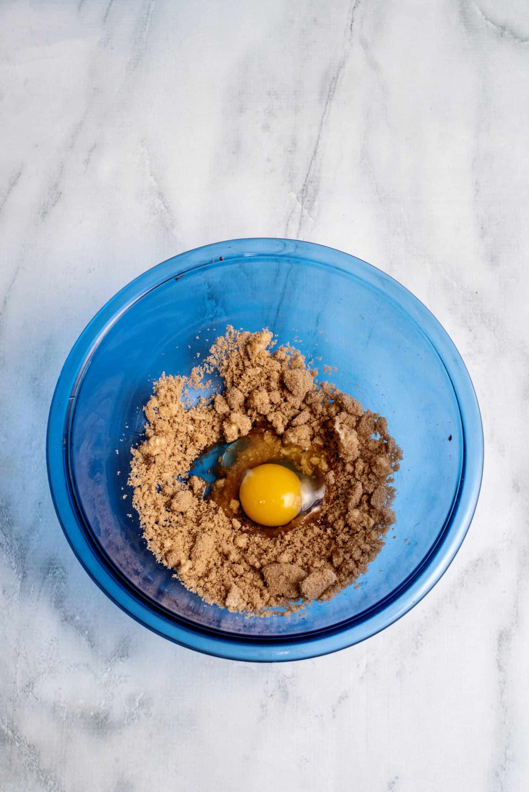 Brown sugar and butter heated with egg added to bowl 