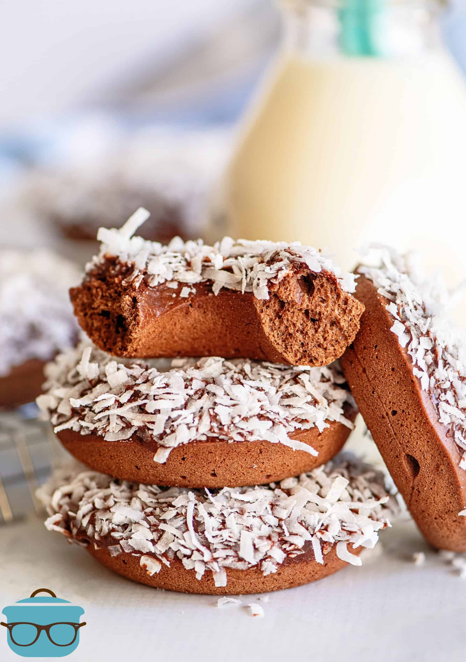 Stacked Chocolate Coconut Baked Donuts with one donut broken in half