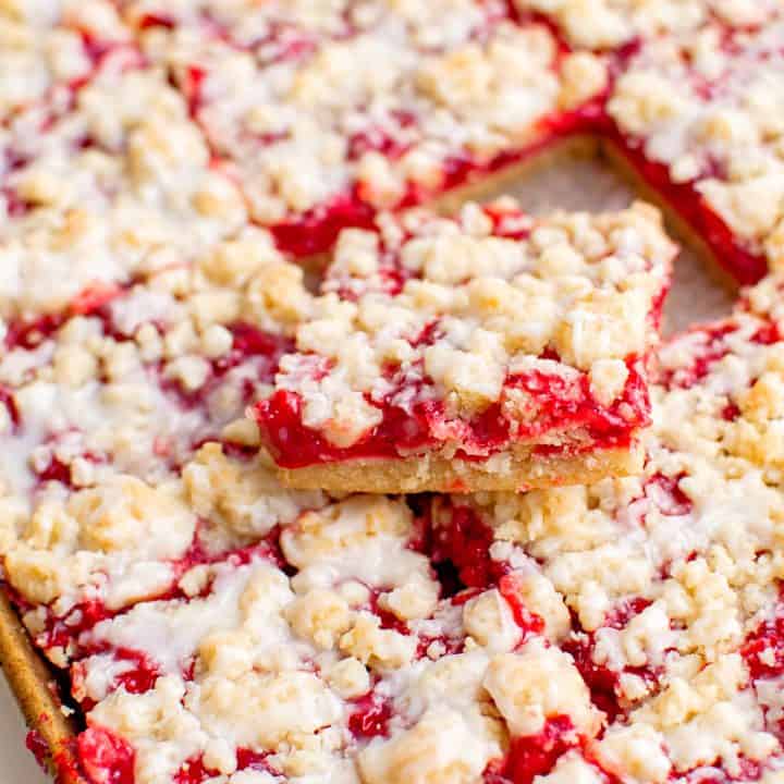 Square image of Cherry Crumble Bar Recipe in pan with one bar sticking out the top stacked