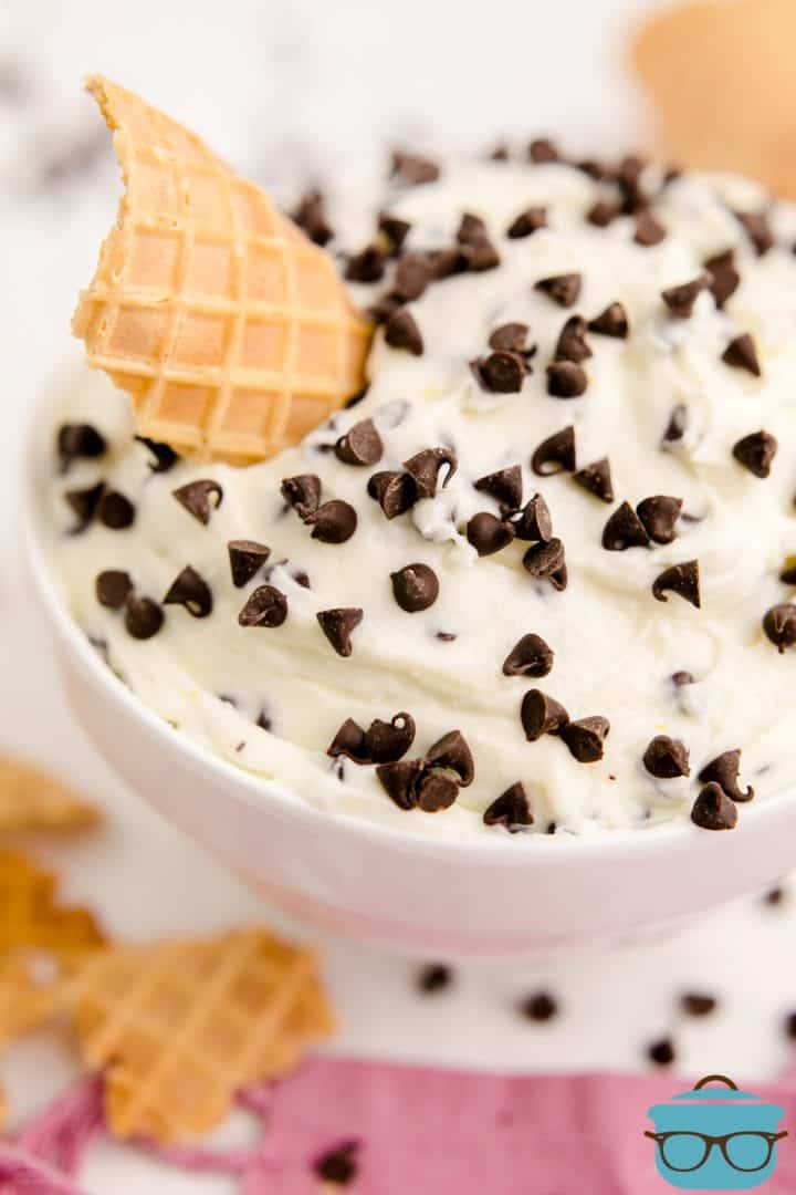 Cannoli Dip in bowl with chocolate chips and waffle cone piece