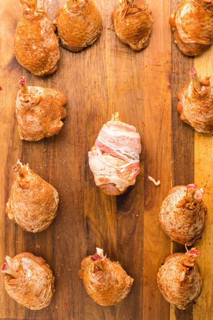 Drumstick wrapped with bacon on cutting board