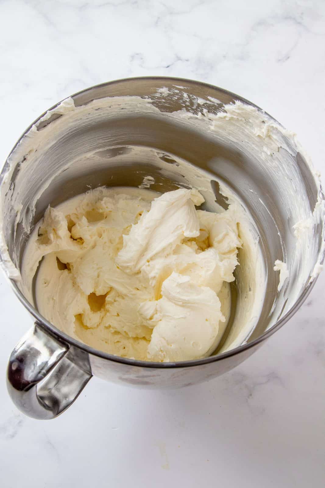 Beaten cream cheese in bowl of stand mixer.