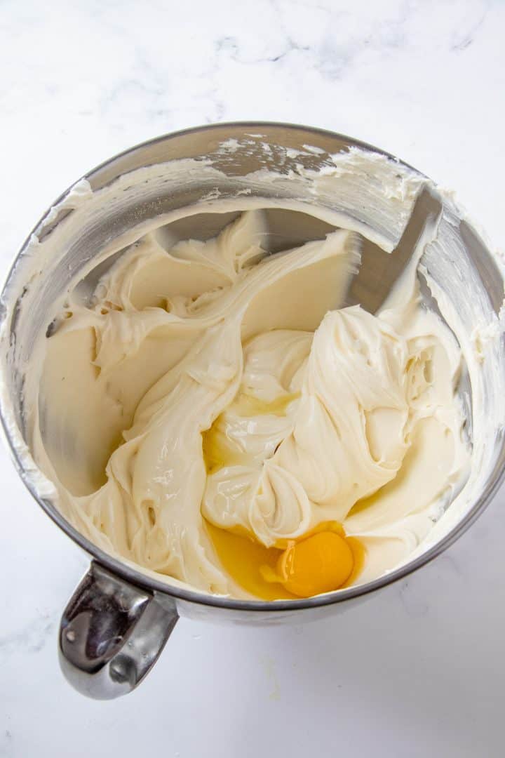 Eggs added to cream cheese mixture in mixing bowl.