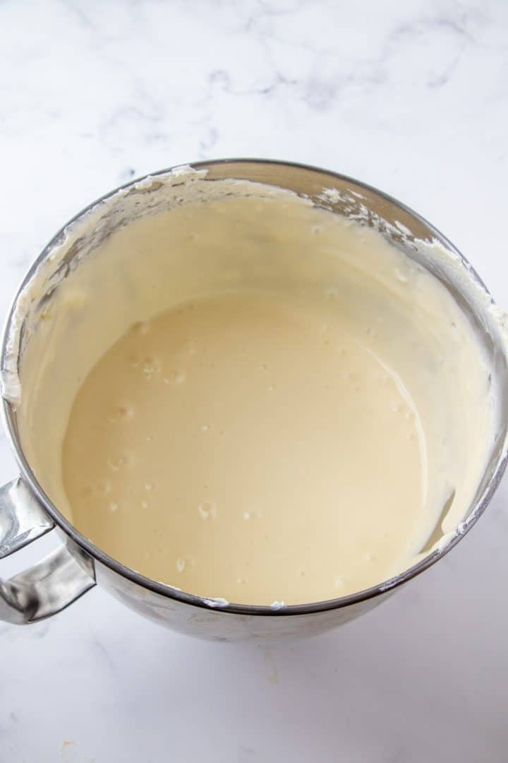 Eggs beaten into cream cheese mixture in mixing bowl.