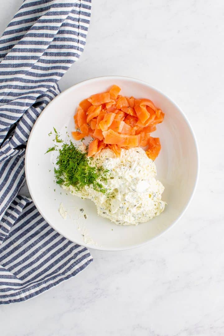 Salmon, dill and cream cheese added to white bowl