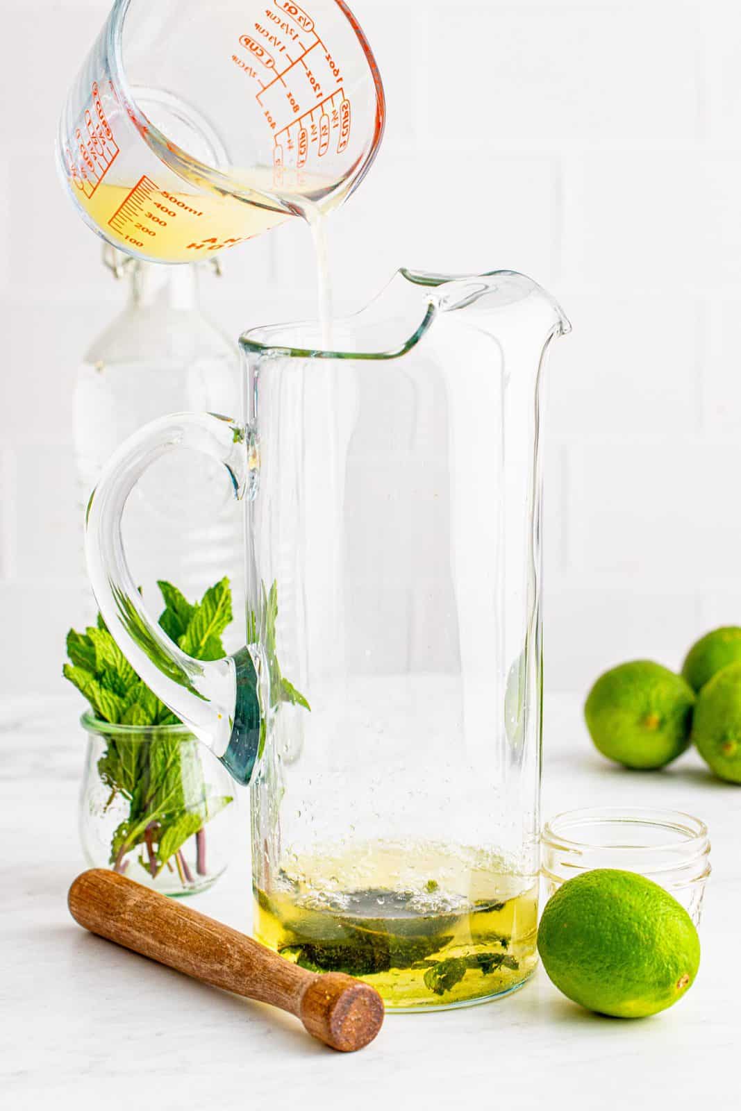 Lime juice being poured into a pitcher.
