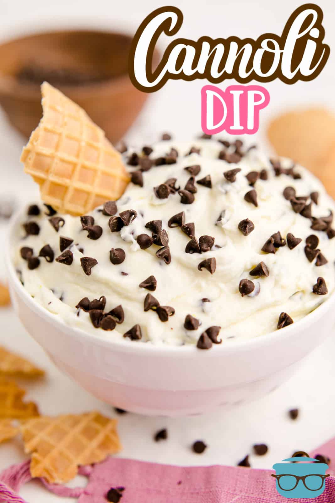 Finished Cannoli Dip in white bowl with chocolate chips and waffle cone in bowl Pinterest image.