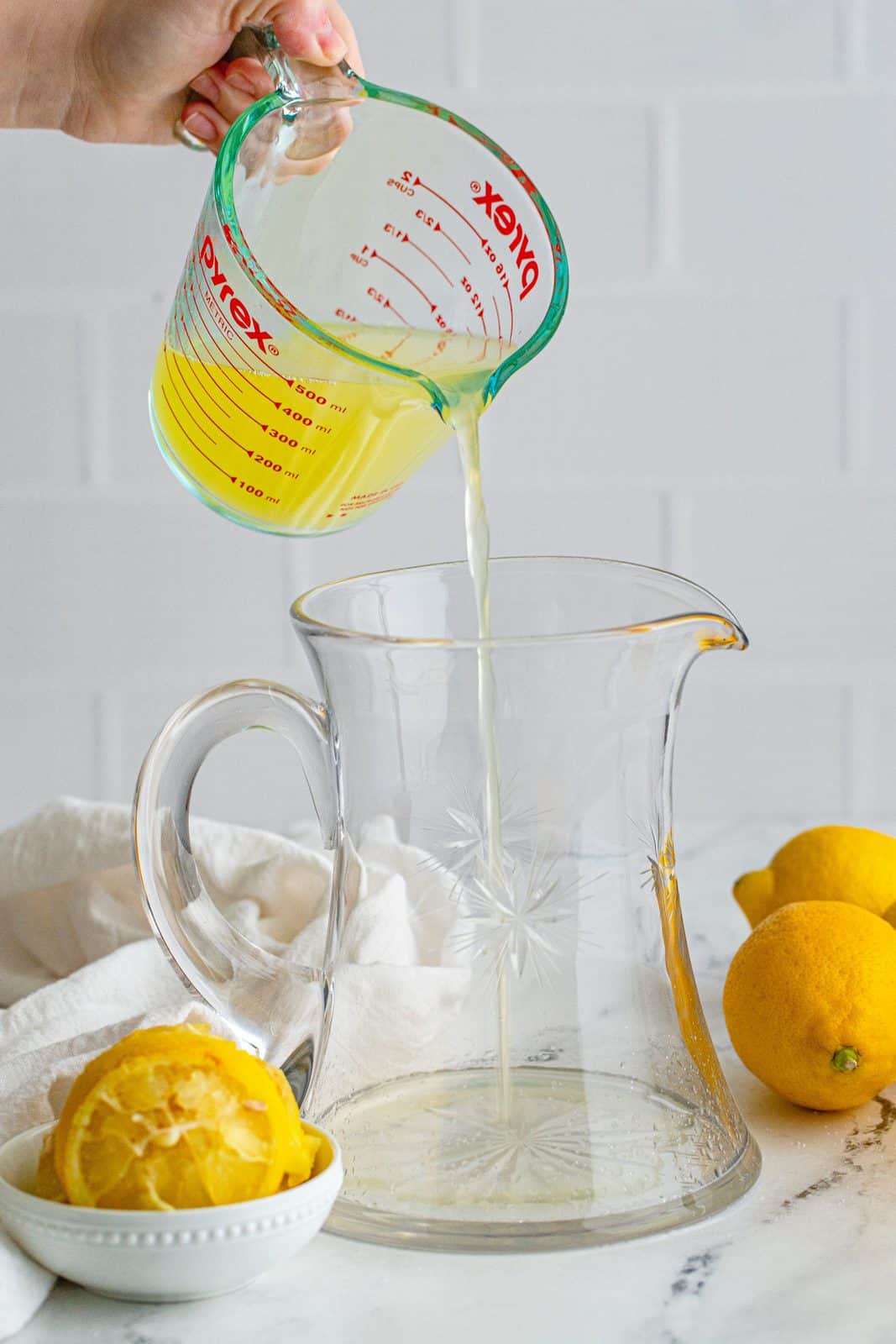 Lemon juice being poured into pitcher.