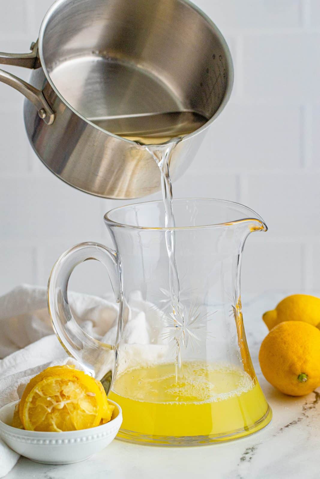 Simple syrup being poured into pitcher.