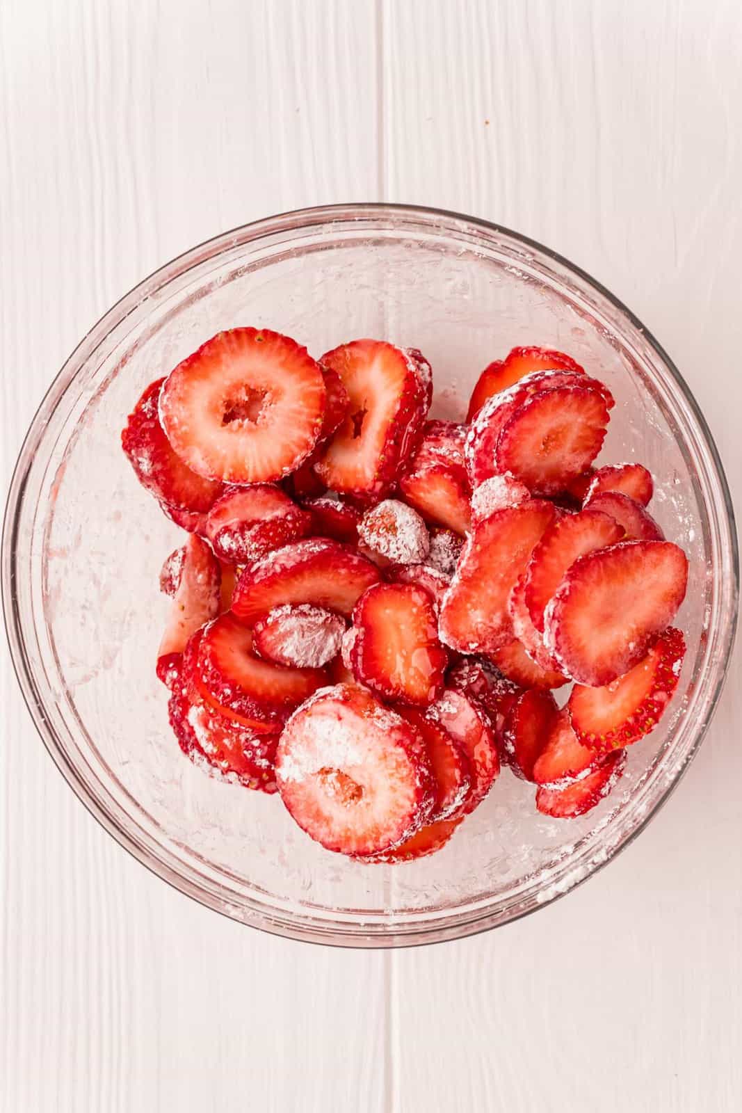 Strawberries in bowl tossed with cornstarch and sugar