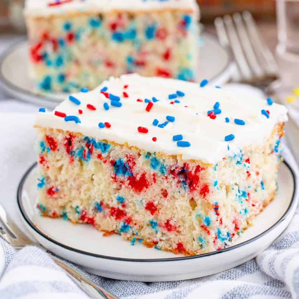 Square image of one slice of Funfetti Cake on white plate