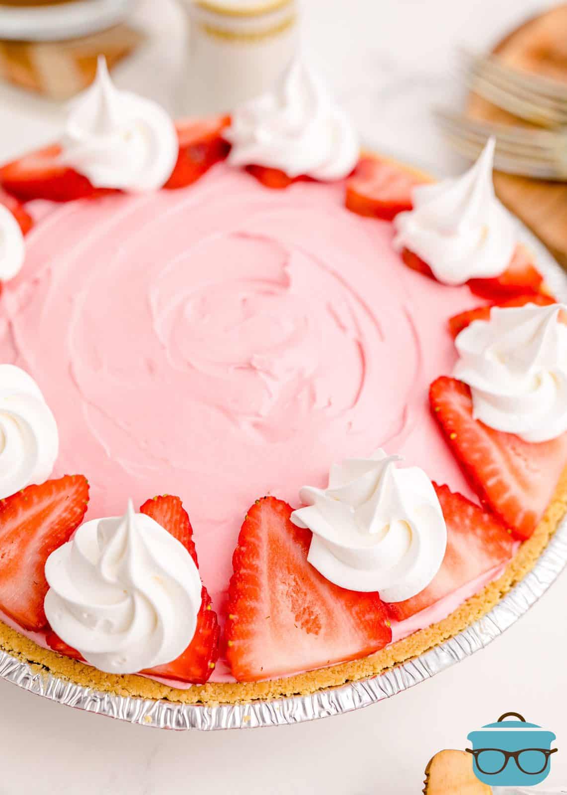 Strawberry Kool-Aid Pie garnished with sliced strawberries and cool whip.