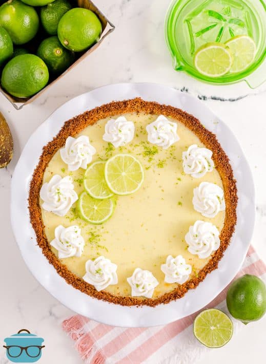 Overhead of finished Homemade Key Lime Pie topped with whipped cream and lime slices