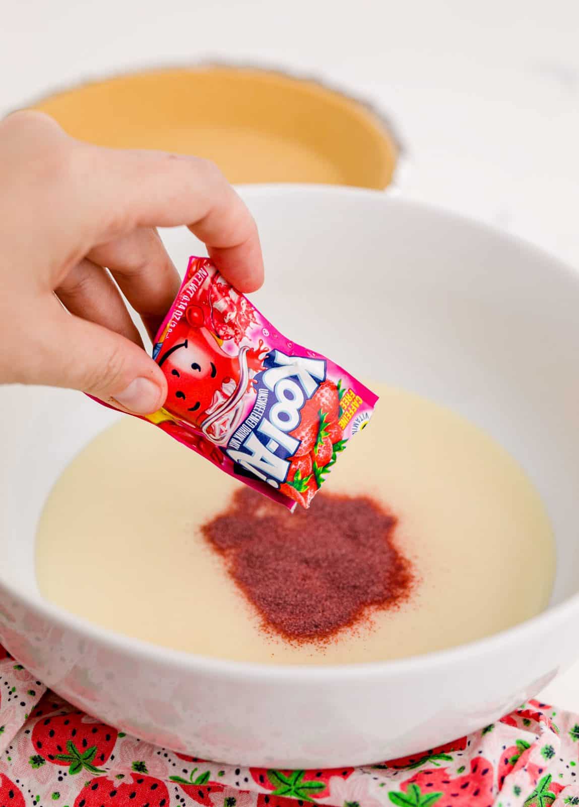 Kool-Aid being sprinkled into the bowl with sweetened condensed milk.