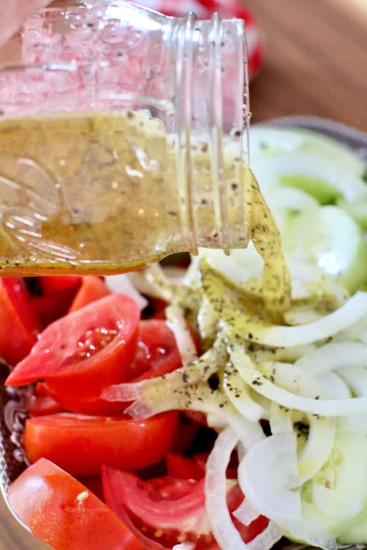 pouring marinade over sliced vegetables in a bowl.