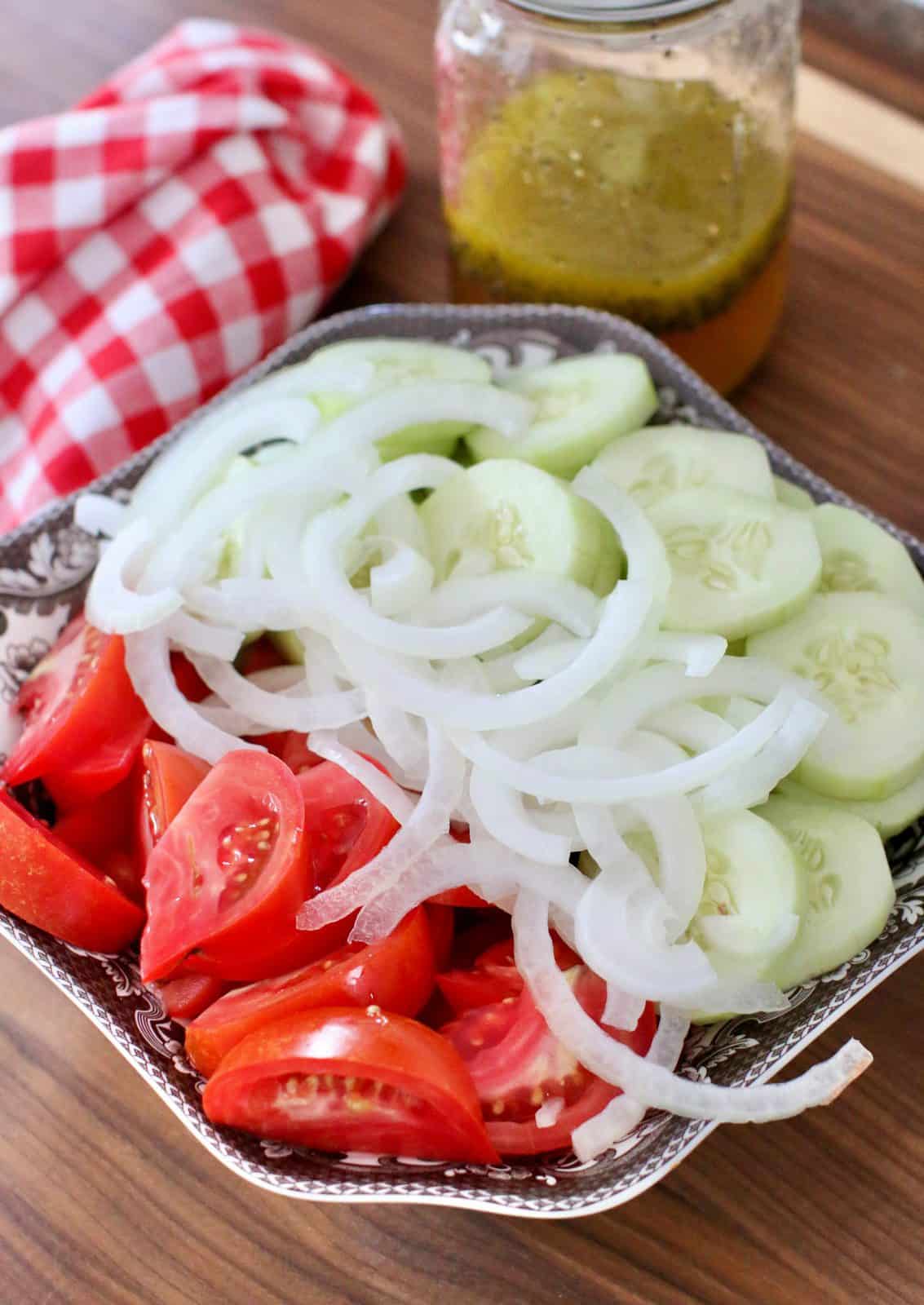 sliced tomatoes, onion and cucumbers in a bowl.