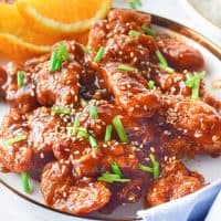 Square image of plated Air Fryer Orange Chicken with sesame seeds