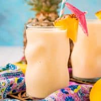 Square image up close of Pineapple smoothie in glass garnished