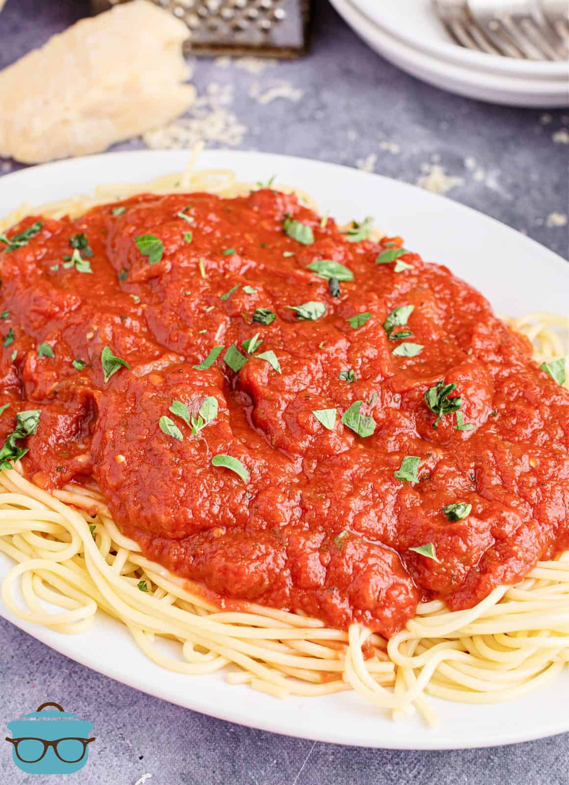 Homemade Marinara Sauce over a bed of spaghetti on platter.