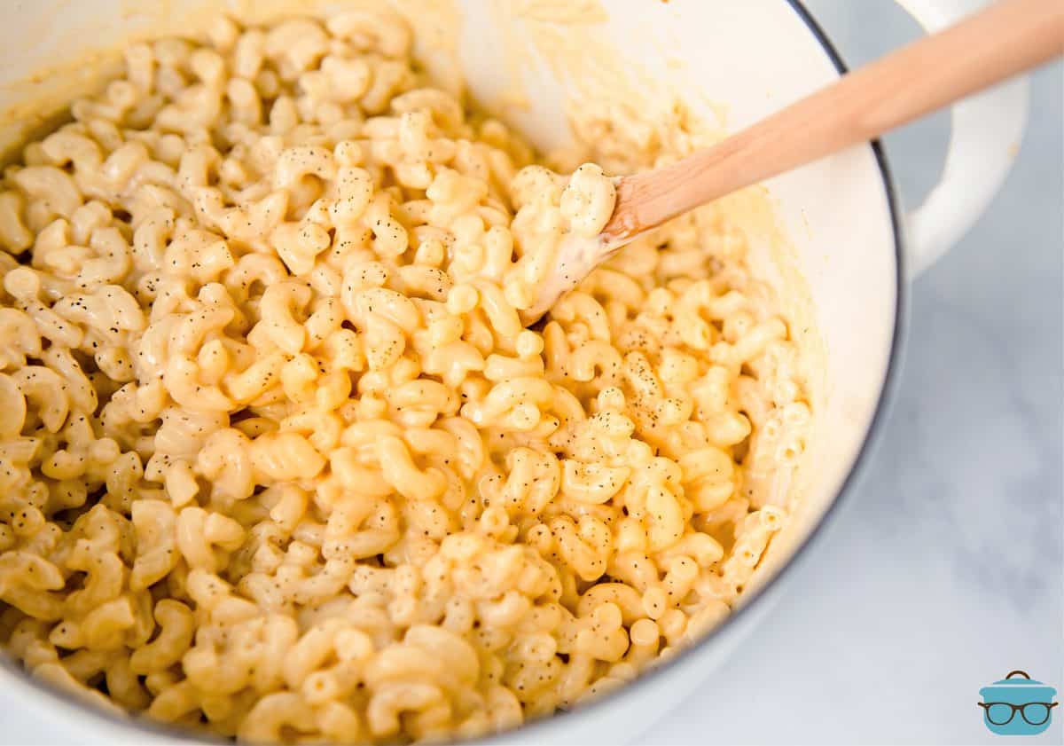 Stove Top Macaroni and Cheese in dutch oven with wooden spoon.