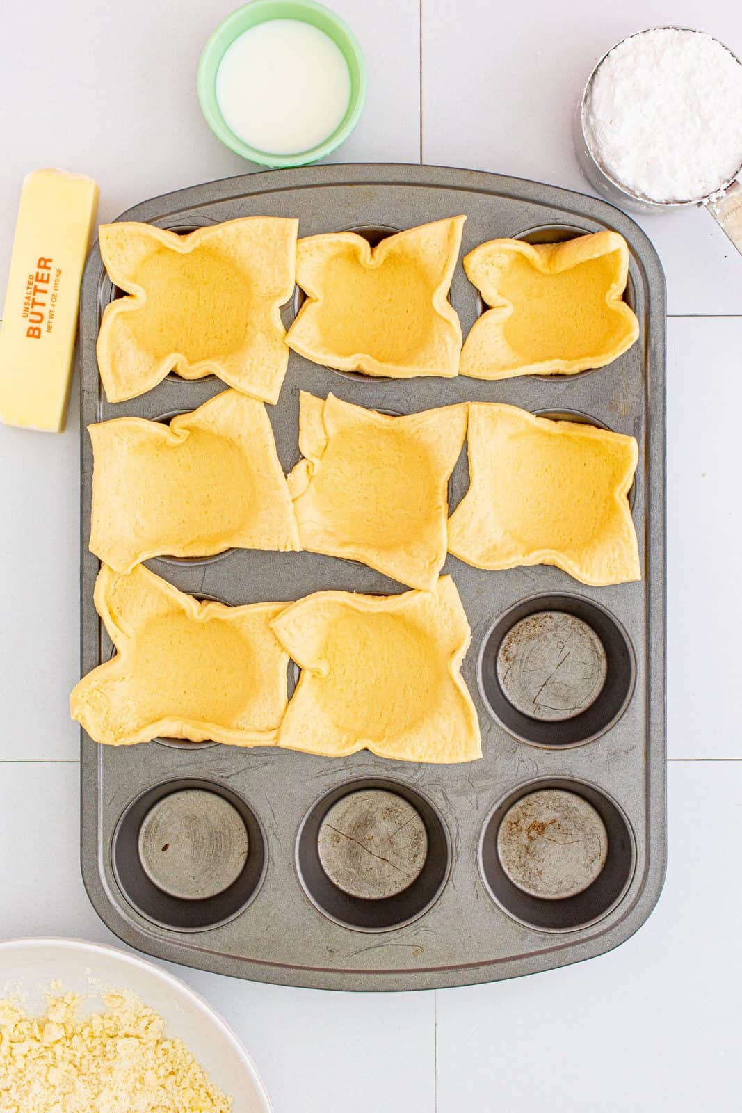 Crescent squares added to prepared muffin tin.
